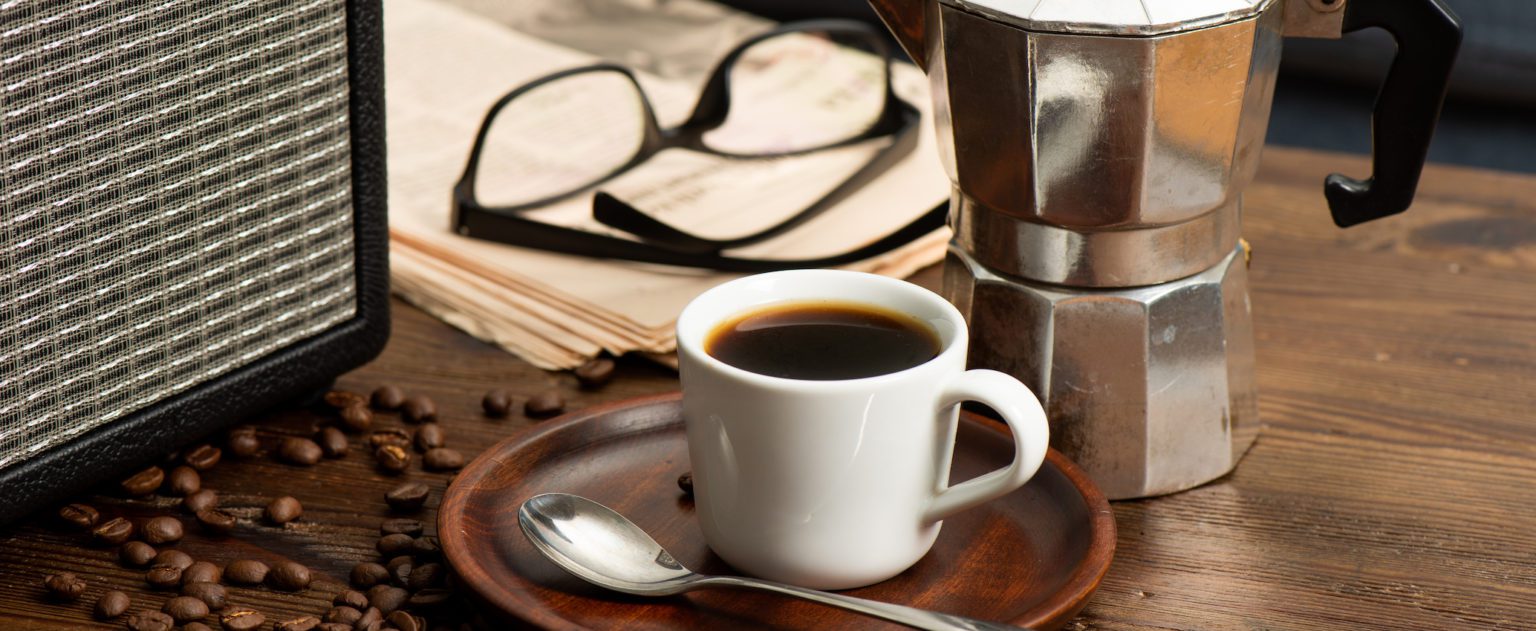 White cup of coffee with coffee beans.